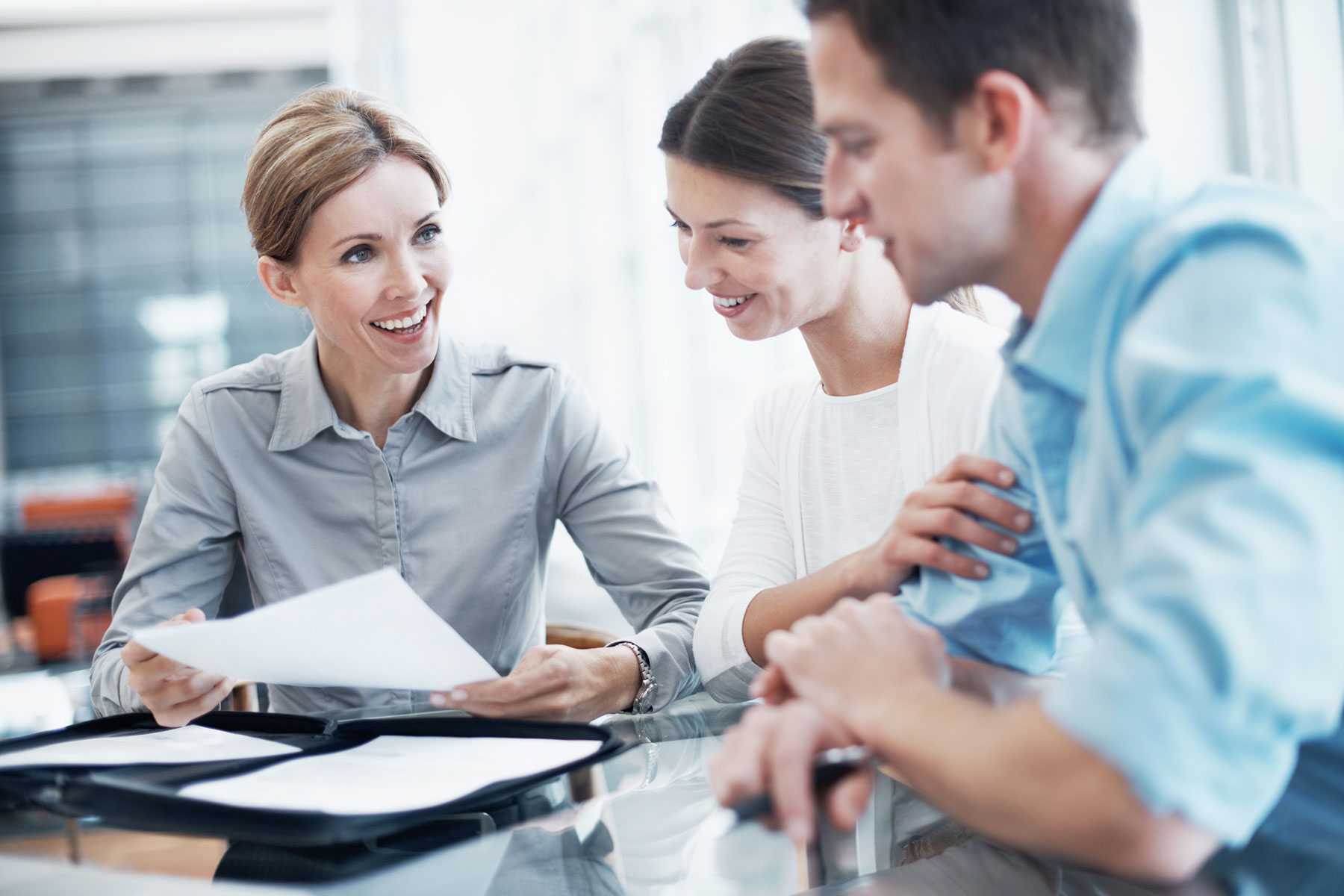 Three people discussing paper work
